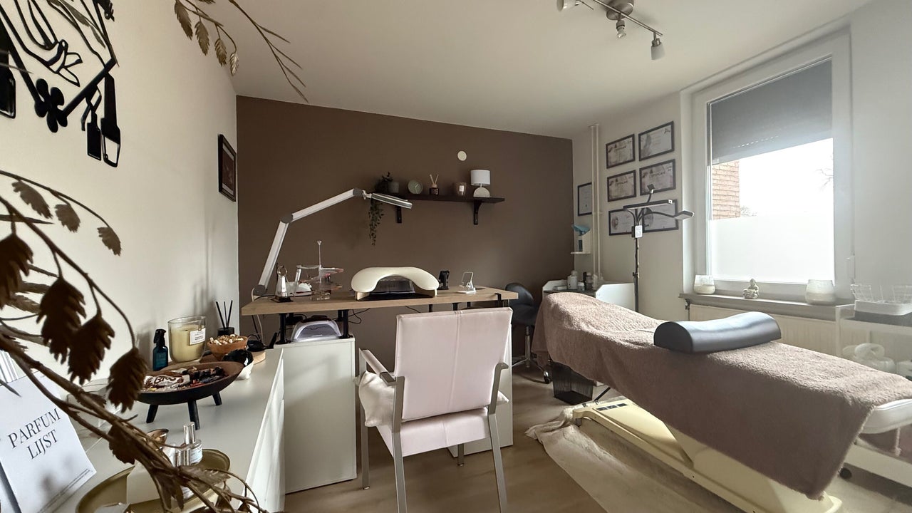 De salon van J’s Beautybar: nageltafel met lamp, behandelbank en de taupe wand