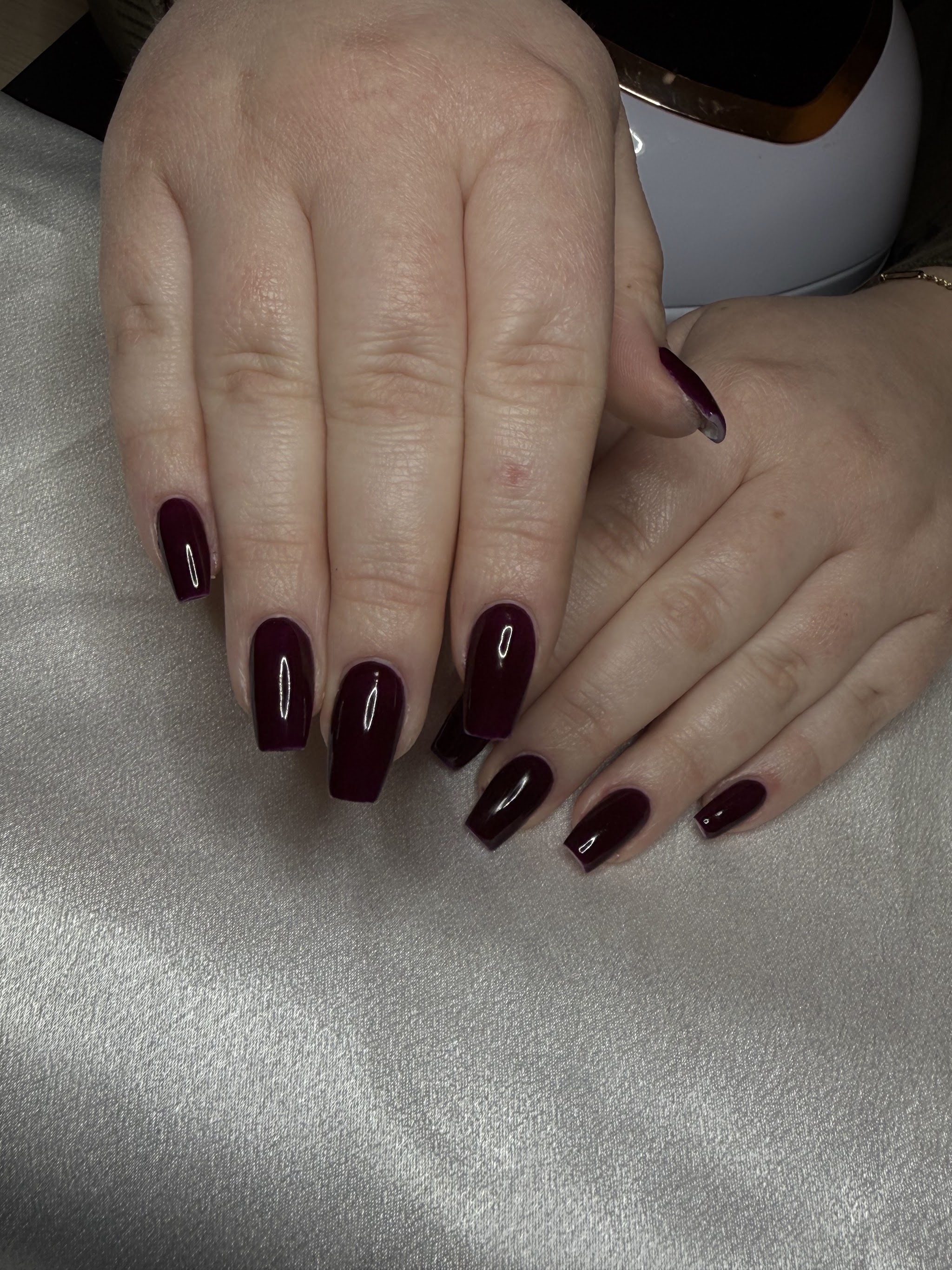 Lange donker bordeaux nagels op zilver satijn